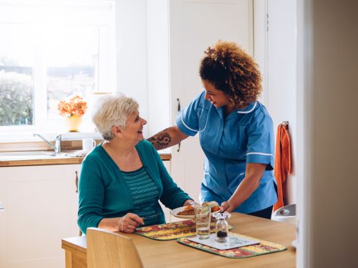 Une aide à domicile aide votre proche à prendre son repas Une aide à domicile aide votre proche à prendre son repas